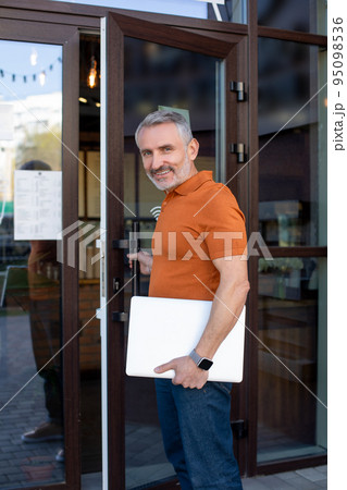 Mature confident man with notebook at the cafe entrance 95098536