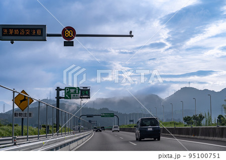 朝の新東名高速道路を走る乗用車 まもなく清水パーキングの入り口 朝の新東名高速道路を走る乗用車 まもなく清水パーキングの入り口 95100751