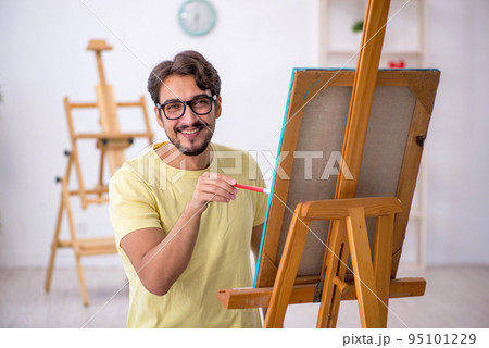 Young man enjoying painting at home 95101229