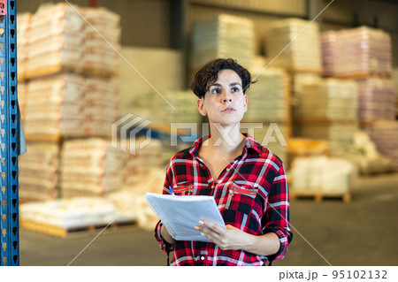 Woman checking documentation in warehouse 95102132