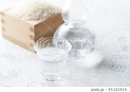 グラスのお猪口に注いだ日本酒 95102919