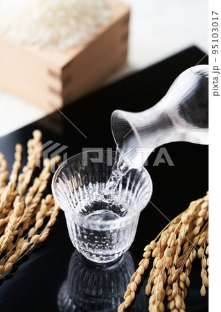 グラスのお猪口に日本酒を注ぐ グラスのお猪口に日本酒を注ぐ 95103017