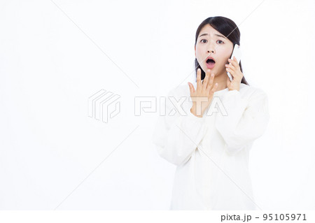 スマホで話しながらビックリしている30代の女性 95105971