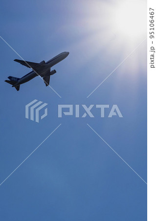 太陽に向かって上昇するジェット旅客機 95106467