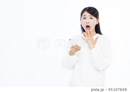 スマホを持ってビックリしている30代の女性 スマホを持ってビックリしている30代の女性 95107608