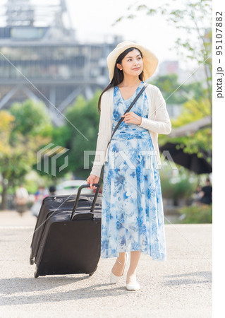 スーツケースを引いて名古屋観光をする若い女性 95107882