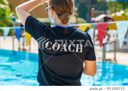 Back view of female swimming coach, wearing COACH shirt Back view of female swimming coach, wearing COACH shirt 95109535