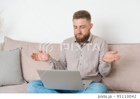 Smiling young caucasian bearded man making video call with friends while Smiling young caucasian bearded man making video call with friends while 95110042