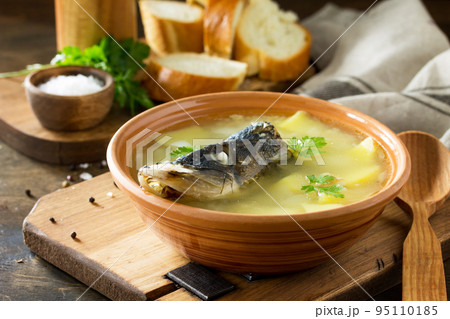 Fish soup from pike, with caviar on a wooden table in a rustic style. Traditional Russian cuisine. 95110185