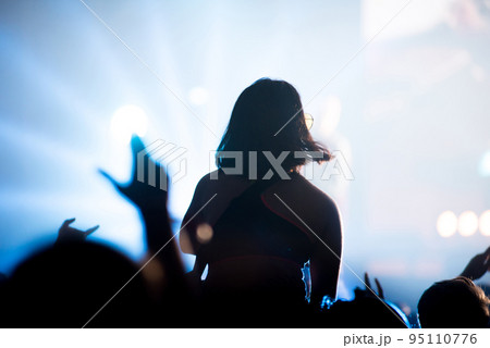 Silhouette of concert crowd in front of bright stage lights Silhouette of concert crowd in front of bright stage lights 95110776