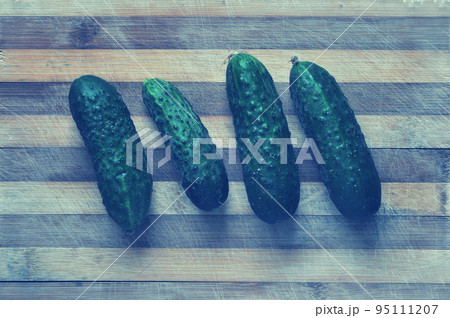Green cucumbers on a cutting board 95111207