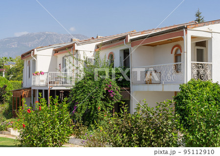 Low white houses against a blue sky with a mountain. Low white houses against a blue sky with a mountain. 95112910