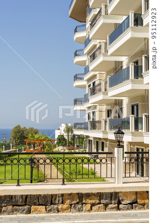 A new modern building with a fenced area on the sea coast. A new modern building with a fenced area on the sea coast. 95112923