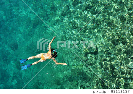 Young woman snorkeling in transparent shallow sea Young woman snorkeling in transparent shallow sea 95113157