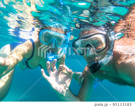 Underwater view of snorkeling couple in the sea Underwater view of snorkeling couple in the sea 95113183