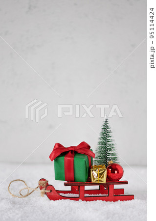 Miniature sledge with Christmas presents, ornament and Christmas tree. Merry Christmas and Happy New Year greeting card. 95114424