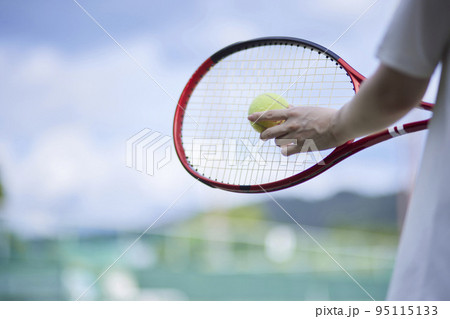 テニスコートでテニスをする若い日本人女性 95115133