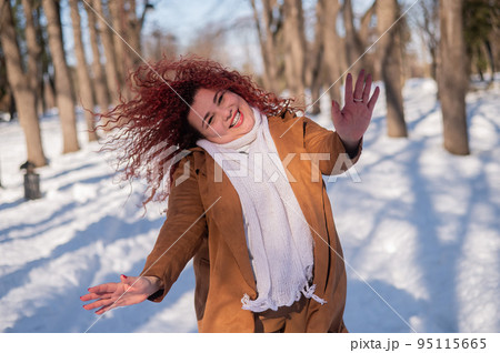 Fat caucasian woman dancing on a walk in the park in winter.  95115665
