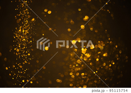 Warm glowing golden glitter festive lights abstract bokeh dark background 95115754