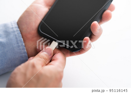 スマートフォンを充電する男性の手 スマートフォンを充電する男性の手 95116145