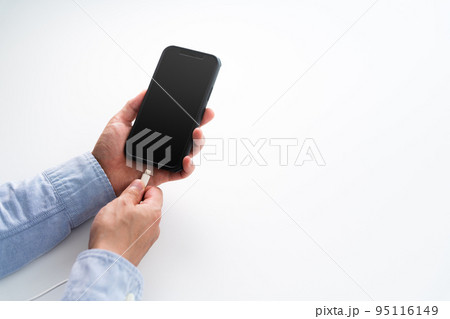 スマートフォンを充電する男性の手 スマートフォンを充電する男性の手 95116149