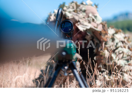 army soldier holding sniper rifle with scope and aiming in forest. war, army, technology and people concept army soldier holding sniper rifle with scope and aiming in forest. war, army, technology and people concept 95116225