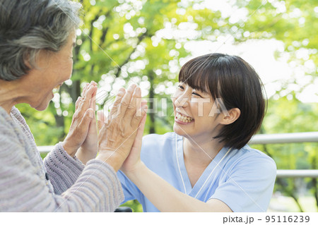 車椅子に乗ったシニア女性と女性医療従事者 95116239