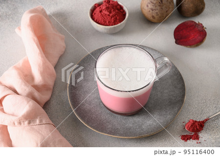 Beetroot latte or pink moon milk latte in glass cup on gray background. Great warming drink. 95116400
