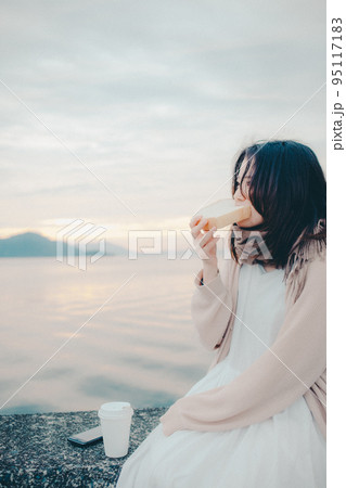 朝焼けが綺麗なパンを食べる女性の写真 朝焼けが綺麗なパンを食べる女性の写真 95117183