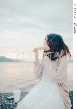 朝焼けが綺麗なパンを食べる女性の写真 朝焼けが綺麗なパンを食べる女性の写真 95117184