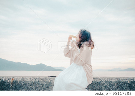 朝焼けが綺麗なパンを食べる女性の写真 朝焼けが綺麗なパンを食べる女性の写真 95117202
