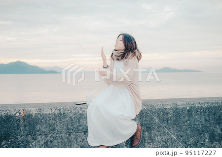 朝焼けが綺麗なパンを食べる女性の写真 朝焼けが綺麗なパンを食べる女性の写真 95117227