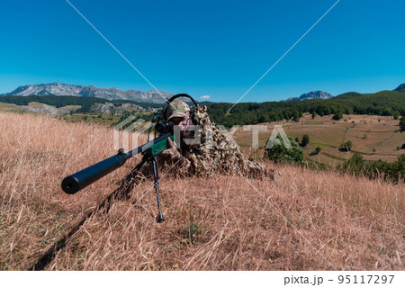 army soldier holding sniper rifle with scope and aiming in forest. war, army, technology and people concept 95117297