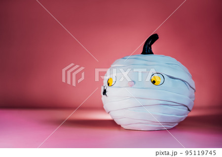 Funny and cute pumpkin mummy with spider on the pink background. White Pumpkin with Confused and worried look. Halloween decor and background with copy space. Selective focus. Funny and cute pumpkin mummy with spider on the pink background. White Pumpkin with Confused and worried look. Halloween decor and background with copy space. Selective focus. 95119745