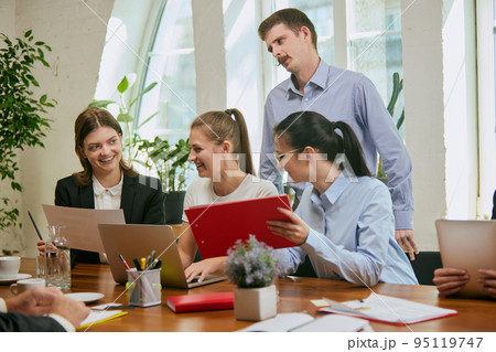 Group of mixed ages people talking, working with colleagues, co-workers at loft style office. Business, urban lifestyle, work, finance, tech concept. 95119747