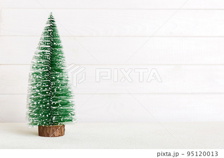 One small Christmas tree on colored background. new year decoration with copy space 95120013