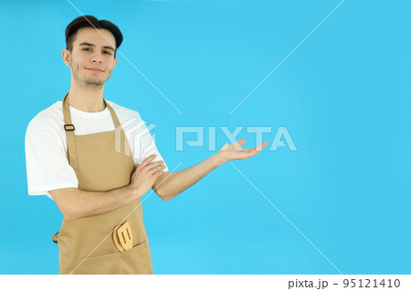 Concept of cooking, young man chef on blue background Concept of cooking, young man chef on blue background 95121410