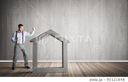 Stone home silhouette in empty room as symbol for real estate insurance Stone home silhouette in empty room as symbol for real estate insurance 95121648