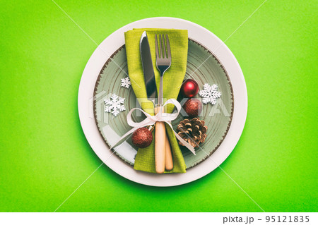 Christmas table place setting with christmas decor and plates, kine, fork and spoon. Christmas holiday background. Top view with copy space Christmas table place setting with christmas decor and plates, kine, fork and spoon. Christmas holiday background. Top view with copy space 95121835
