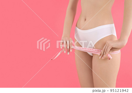 Concept of weight loss, young woman on pink background 95121942