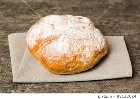 Assortment of freshly baked bread with napkin on rustic table top view. Healthy unleavened bread. French bread Assortment of freshly baked bread with napkin on rustic table top view. Healthy unleavened bread. French bread 95122034