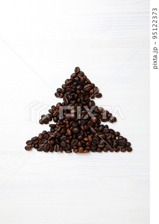 Christmas tree made of coffee beans on white wooden background Christmas tree made of coffee beans on white wooden background 95122373