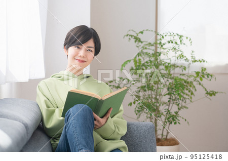 リビングで本を読む若いの女性 リビングで本を読む若いの女性 95125418