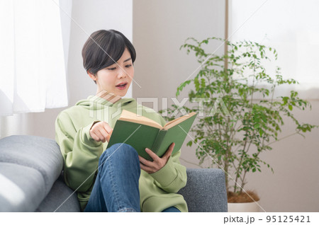 リビングで本を読む若いの女性 リビングで本を読む若いの女性 95125421