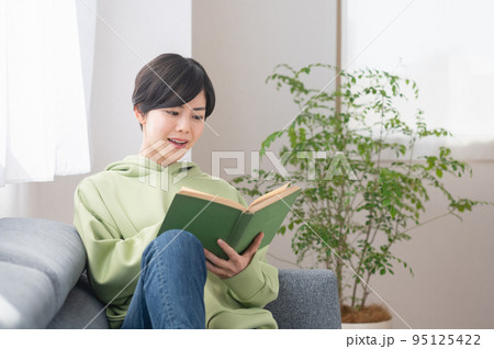 リビングで本を読む若いの女性 リビングで本を読む若いの女性 95125422