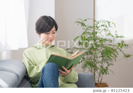 リビングで本を読む若いの女性 リビングで本を読む若いの女性 95125423