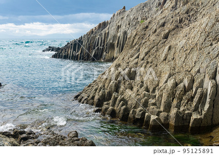 natural landscape with a sheer cliff folded columnar basalt on the seashore natural landscape with a sheer cliff folded columnar basalt on the seashore 95125891