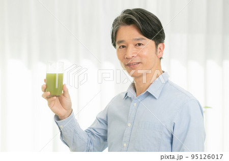 野菜ジュースを飲むミドルの男性 95126017