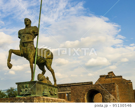 Mythical centaur statue of polish sculptor Igor Mitoraj in the forum of the ancient city of Pompeii, destroyed by the eruption of volcano Vesuvius in 79 AD, Naples, Italy 95130546