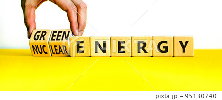 Nuclear or green energy symbol. Businessman turns wooden cubes and changes concept words nuclear energy to green energy. Beautiful white background copy space. Business nuclear green energy concept. Nuclear or green energy symbol. Businessman turns wooden cubes and changes concept words nuclear energy to green energy. Beautiful white background copy space. Business nuclear green energy concept. 95130740
